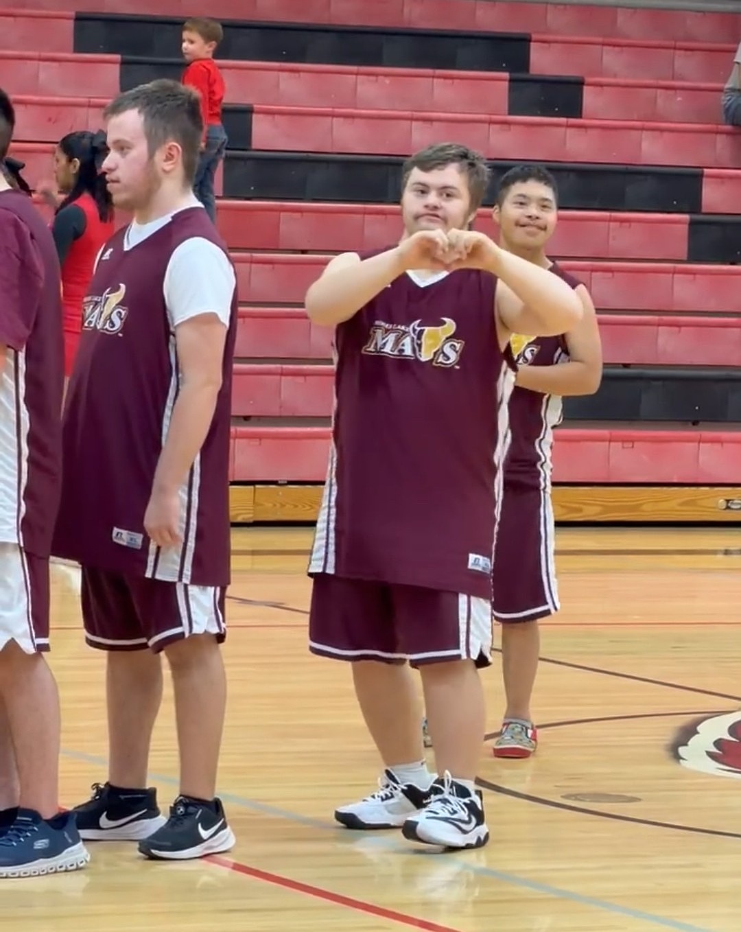 Ethan Farmer, right, makes a heart to his mom and fans in the stand. Head Coach Sarah White said unified sports is great for the lifelong connections the players make.