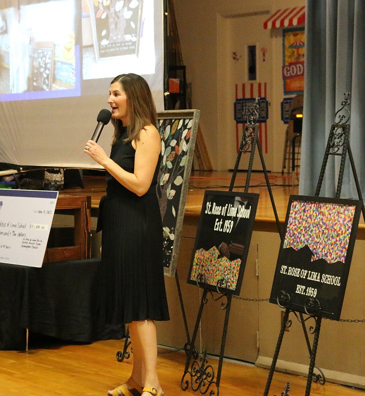 St. Rose of Lima Catholic School third-grade teacher Kelly Sackmann introduces her students’ artwork up for bid at the school's annual fundraiser auction. The school, which is adding middle school classes this fall, has a policy of never turning away students based on ability to pay.