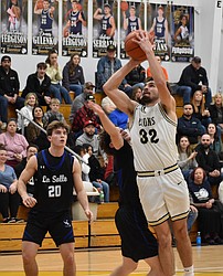 Dennis Gulenko, a senior for the Lions, shoots for two under pressure from La Salle. Gulenko said the team did a great job in working together to earn the victory.