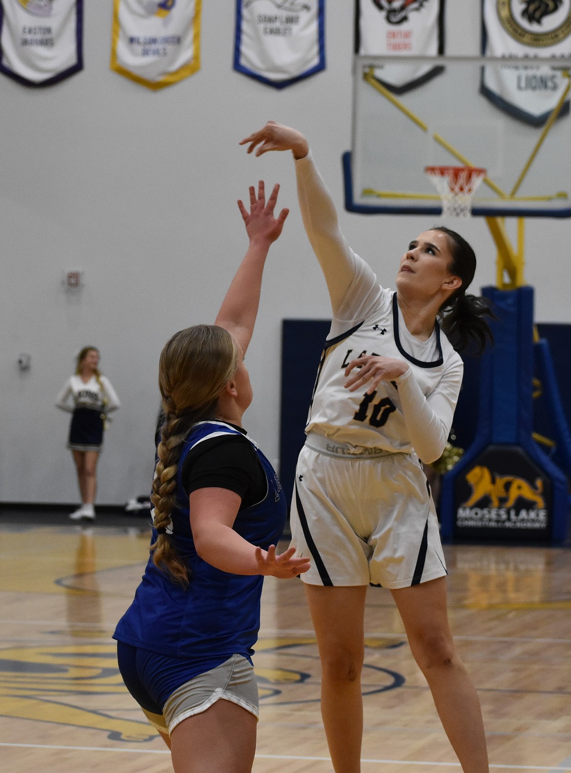 Brynlynn King, a senior from the Lions, shoots for two with pressure from the defense Tuesday evening.