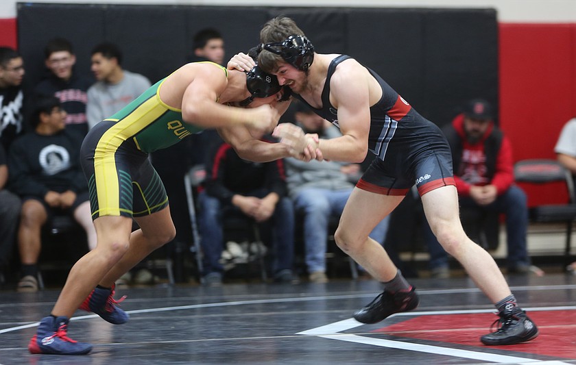 The Huskies’ Mason Russell, right, battles Jorgie Castro III, left, for wrist control. The Huskies boys defeated the Jacks 43-31 Tuesday.