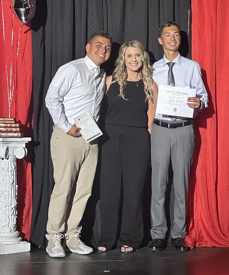 Riley Rodriguez, left, and Sylas Garza, right, receive the Fight for Mike Scholarship for Othello High School students who plan to major in the medical field. Presenting the award is the scholarship fund’s administrator Sarah Montemayor.