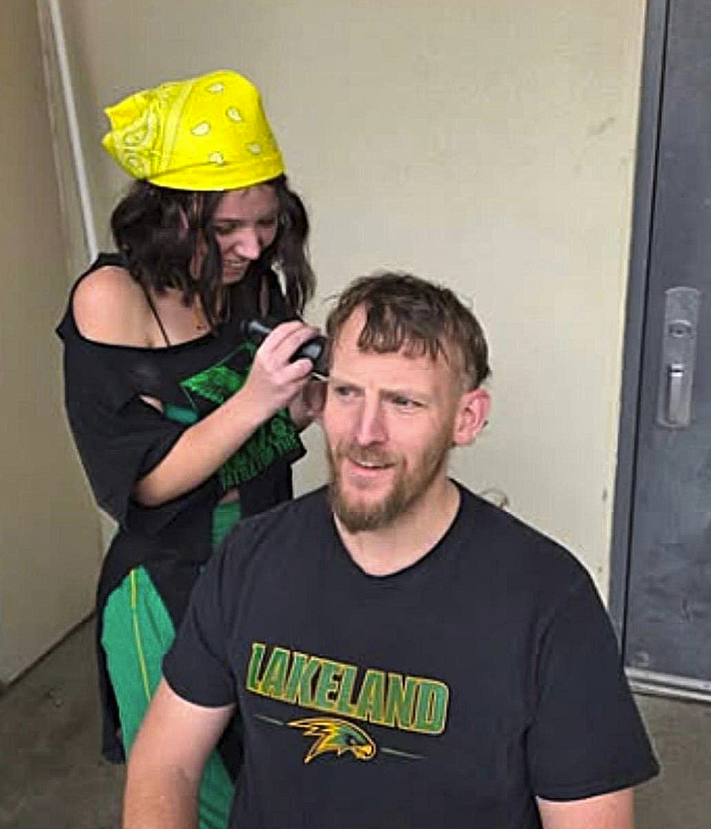Senior Class President Lilly Dotson shaves journalism teacher Mike Dunn's hair into a mullet as part of the 2026 Battle for the Paddle teacher dare festivities.