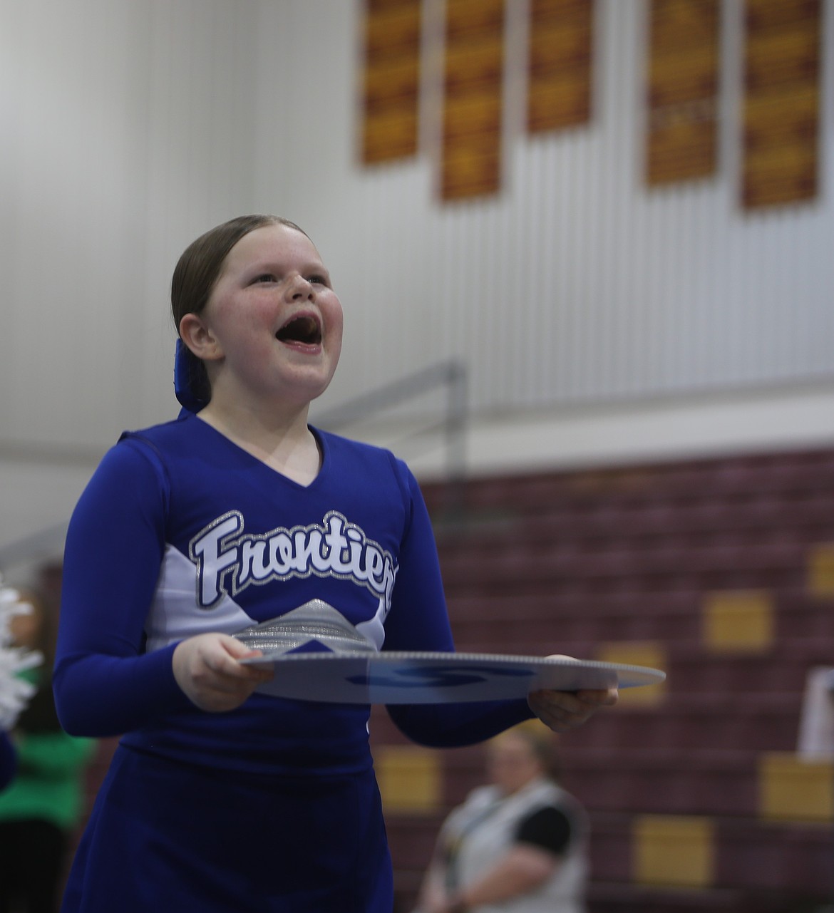 Harley Wiester from Frontier cheers while getting ready to hold up her sign during one of the team performances Saturday at Moses Lake High School.