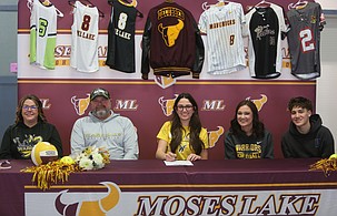 Caitlin Decubber, middle, is joined by her family as she signs her letter of intent to play softball and volleyball at Walla Walla Community College. Decubber said Walla Walla’s welcoming environment helped her decide the Warriors were right for her.