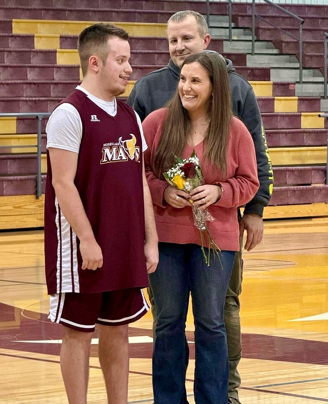 DJ Parker, left, stands with his parents ahead of his final home game.