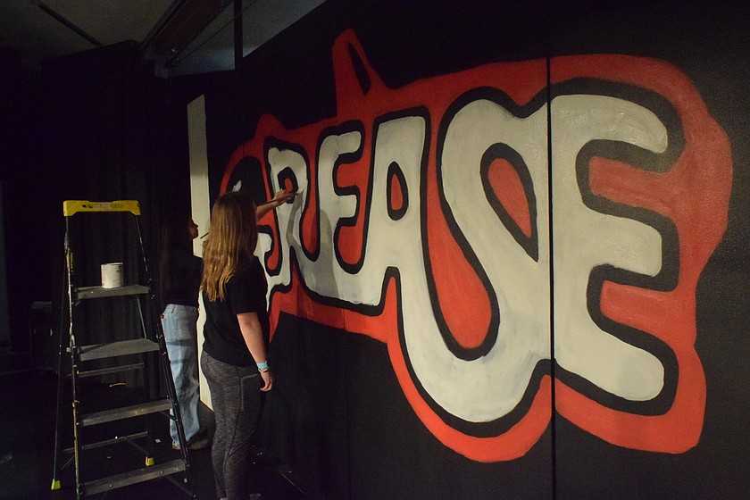 Students paint backdrops for the upcoming production of Grease, which debuts Feb. 12, with five runs.