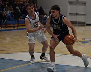 Dennis Gulenko, right, a senior from the Lions rushes ahead of Reece Kane, left, a senior from the Devils to attempt a layup during Thursday’s game.