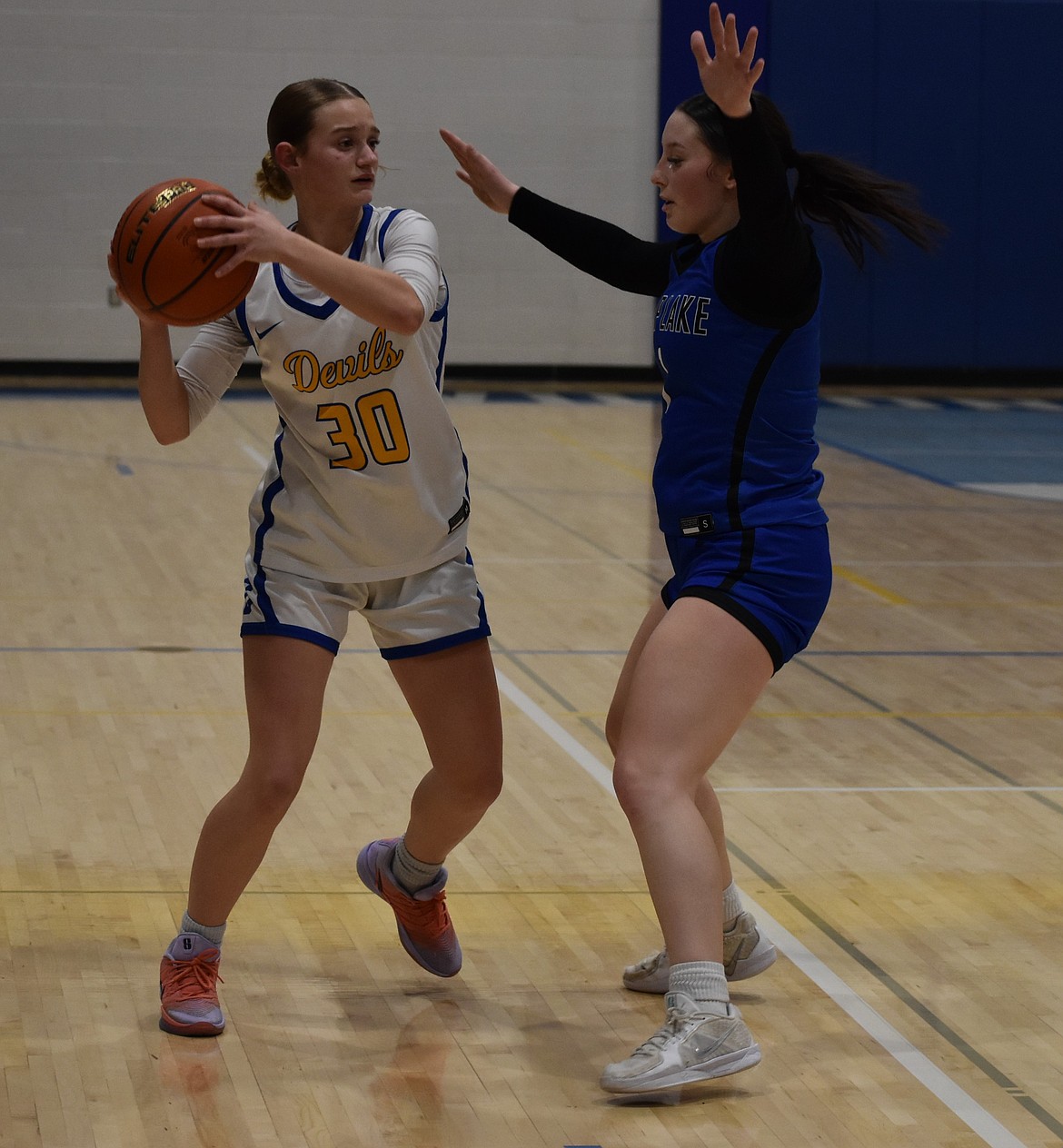 Devils freshman Ady Leslie (30) looks to pass to a teammate while Mylee Dana (1) puts up a defensive front to block the ball.