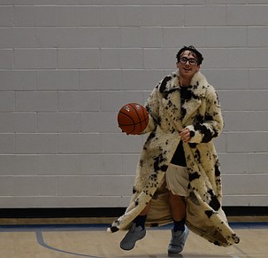 Aiden Galindo, a senior for the Devils, runs onto the court wearing a fur coat during pregame warmups getting ready for his senior night game against the Eagles. Galindo went on to be the top scorer of the night with 12 points.