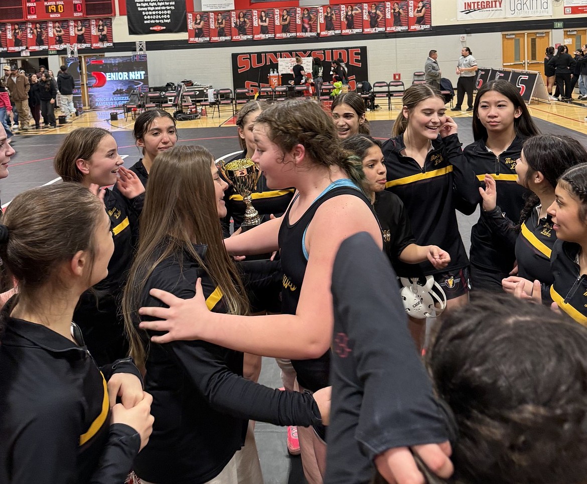 The Mavericks girls wrestling team celebrates winning the Big 9 title and defeating Sunnyside in a comeback win.