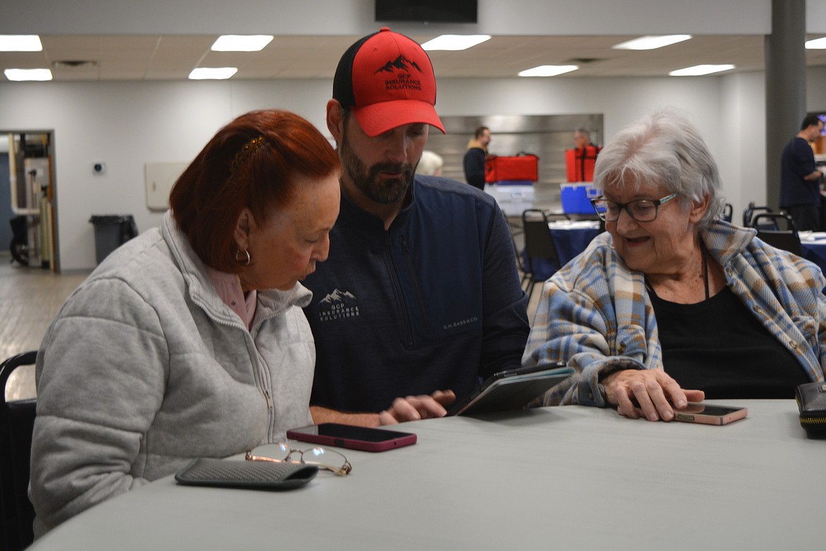 Calvin Peters, center, helps Elaine Cairns with a tech issue at Lake City Center. The senior center offers technology classes with help on the first Wednesday of each month.