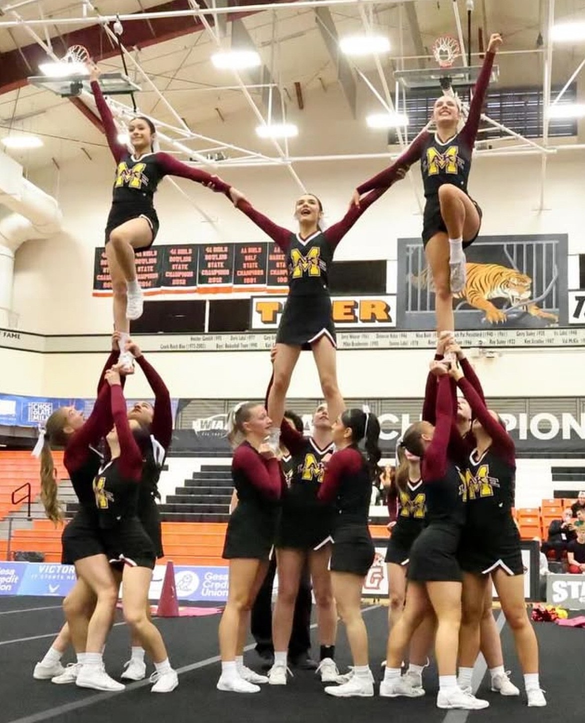 The Mavericks cheer team performs one of their stunts at the state competition in Battle Ground. The Mavericks qualified for state in December after a delayed start to their season due to fall sports.