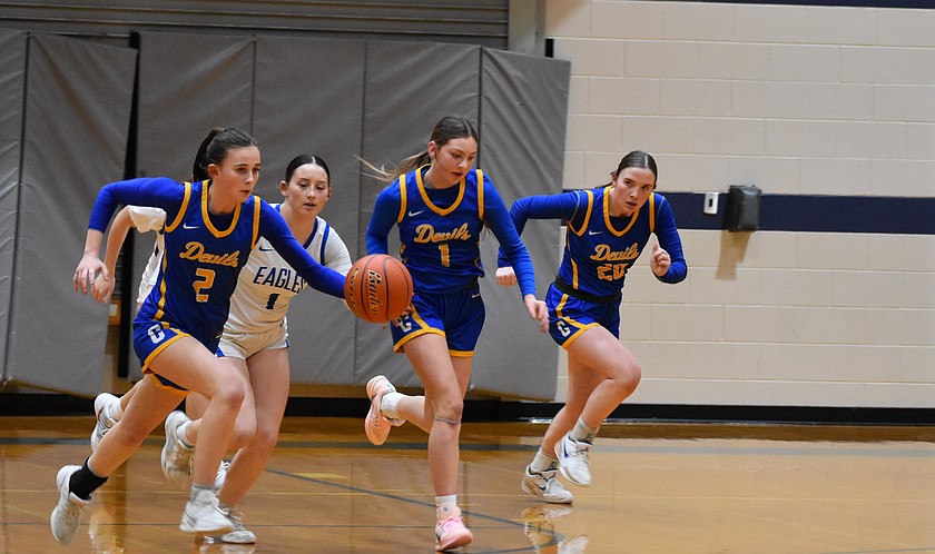 Devils sophomore Kaydence Leslie (2) carries the ball down the court with teammates Reece Voss (1) and Lila Sackmann (20) following behind while Eagles senior Mylee Dana (1) tries to gain possession of the ball.