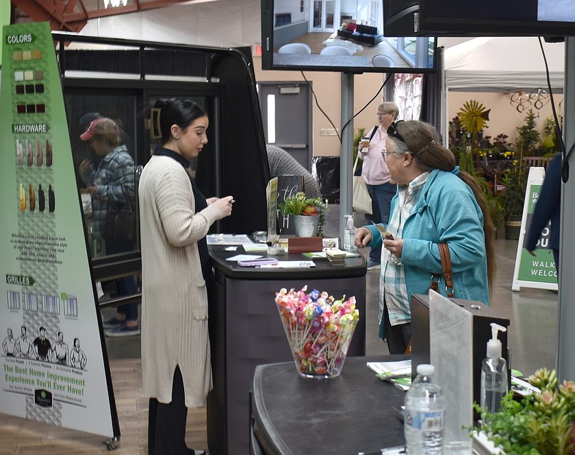Kristina Korotkov, left, of Renewal by Andersen talks with Susan Richins at last year’s Columbia Basin Home and Garden Show. This year’s show is Feb. 27-28.