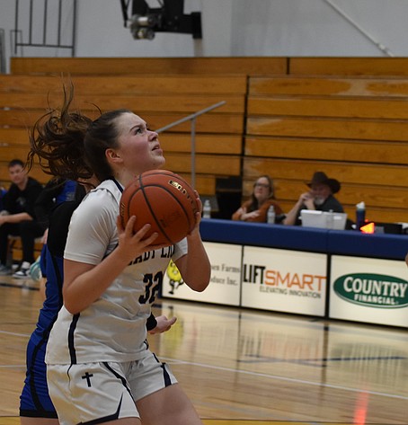 Shay Kast from the Lions works to shoot for two while under pressure during Tuesday’s district game against the Eagles. Kast led the team offensively with 26 points scored.