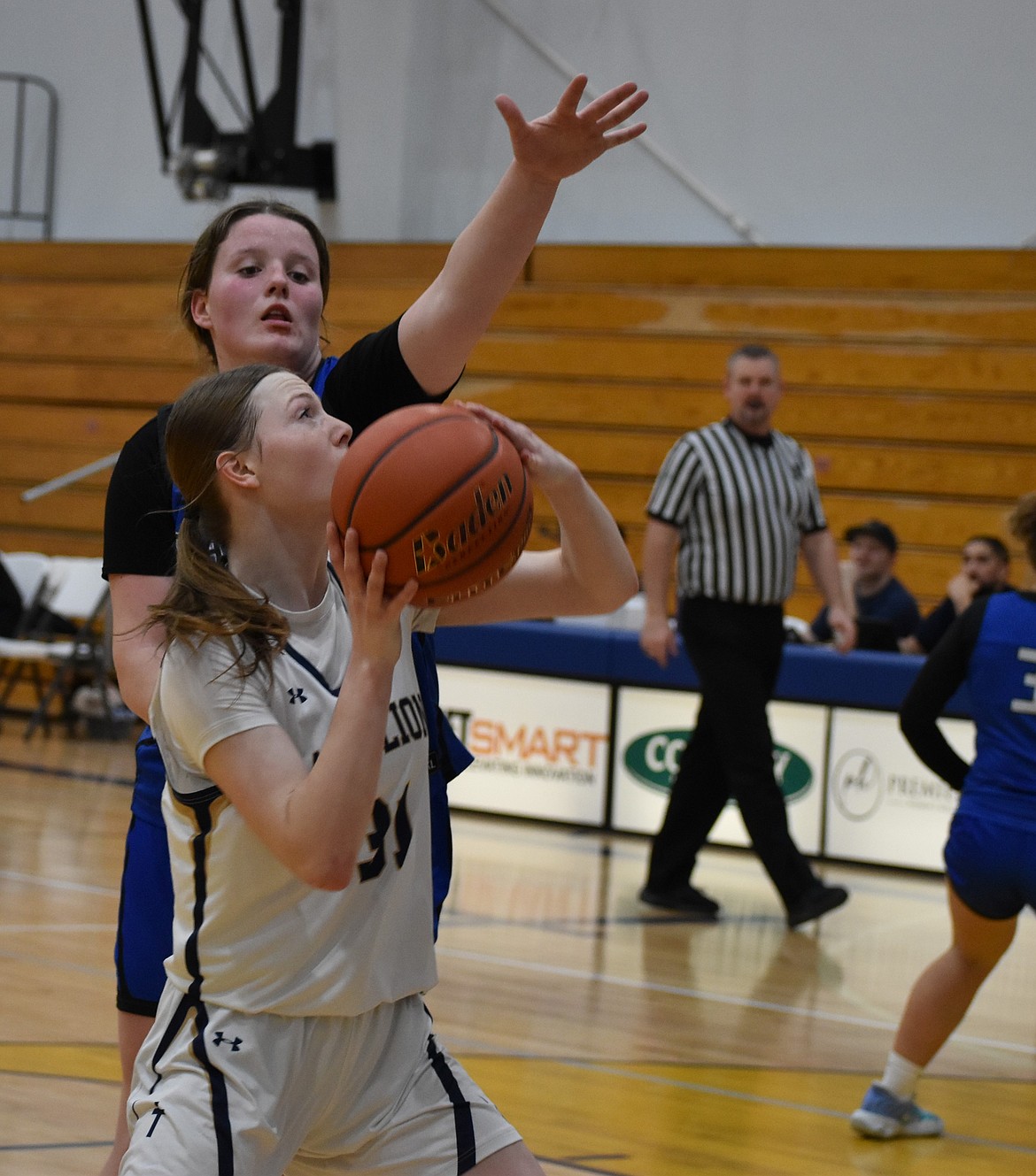 Brooke Dana, a senior from the Eagles, raises her arm to block a shot from Clarissa Shopbell, an eighth-grader from the MLCA.