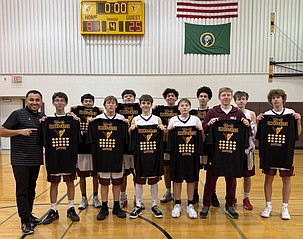 The Mavericks D-team stands together following their final game holding up T-shirts that commemorate their undefeated season. Head Coach Eric Salgado said this was a great turnaround after the team’s struggles last season.