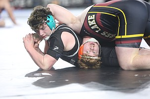 The Mavs’ Eli Anderson, in maroon and yellow, tries to turn his opponent over on his back. Anderson advanced to the semifinals of the Mat Classic after a successful first day Thursday.