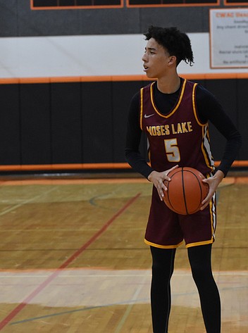 Mavericks senior Tyce Miller scans the court for an open teammate to pass the ball over to during an away game earlier this season.