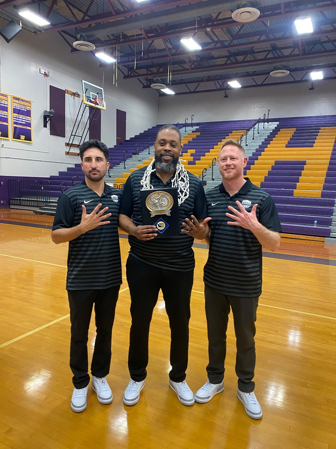 Lions Head Coach Emerson Ferguson, center, stands with his assistant coaches Kameron Firouzi, left, and Curtis Weber, right, as they hold up hardware following the team victory to become 1B District 5 Champions. Ferguson was named Central Washington B League Coach of the Year which he said wouldn’t be possible without the dedication from his assistant coaches.