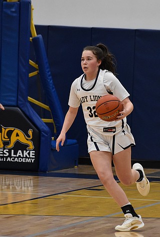 MLCA/CCS freshman Shay Kast gains possession of the ball and runs down to the other side of the court during a previous matchup against Wilson Creek this season. Kast led the Lions with 24 points in Saturday’s district final.