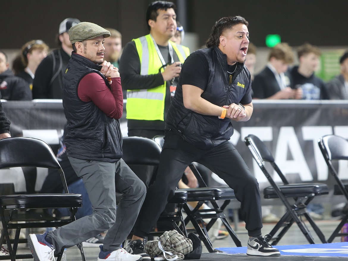 The Mavs’ boys Head Coach Jose Tanguma, right, and an assistant coach calls out to one of their wrestlers during a match at the Mat Classic.
