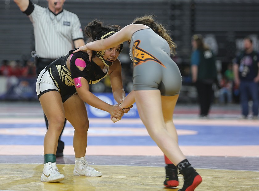 The Knights’ Sharon Arroyo, in black and gold, faces off with her opponent during the 100-lb. semifinals of the Mat Classic. Arroyo was one of four wrestlers on the girls team to make it to the state finals. The Knights won the state title with nine girls winning medals.