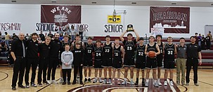 The ACH boys basketball team holds up the 1B District Champions hardware following Saturday’s victory over DeSales.