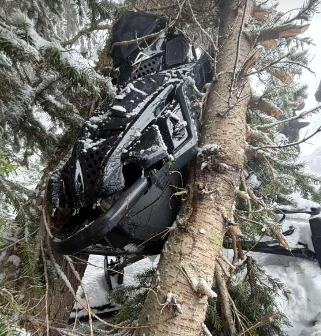 The snowmobile belonging to Tyson Haynes rests by trees after Haynes crashed in the backcountry beyond Lookout Pass on Sunday, Feb. 15.