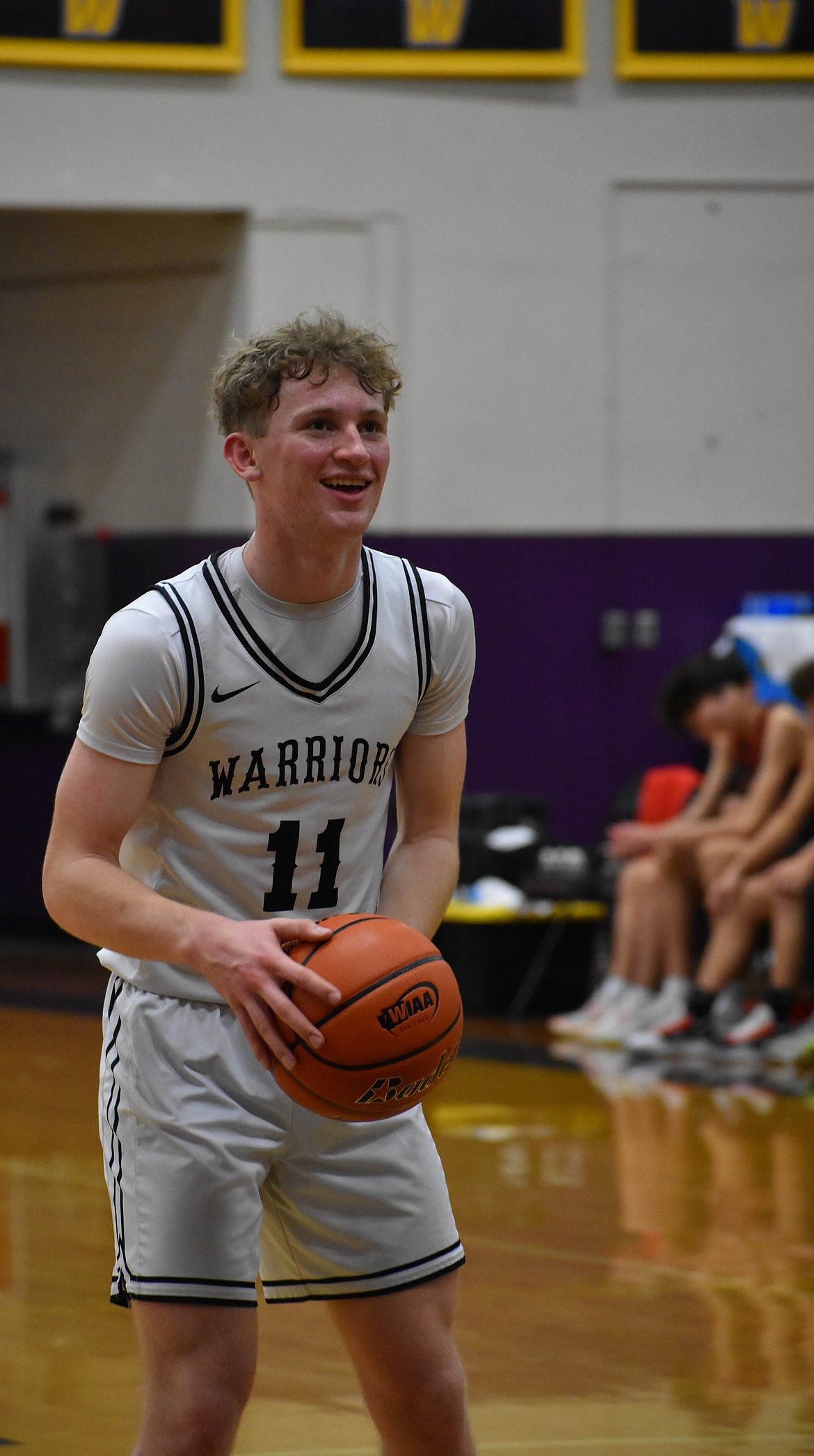 Warriors freshman Nolan Grindy smiles after making his first free throw shot and gets prepared to go for a second shot against Neah Bay in the state tournament.