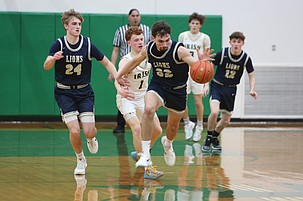 Dennis Gulenko (32) forces a steal and breaks ahead of a DeSales player during their game Saturday. The Moses Lake Christian Academy/Covenant Christian School Lions suffered an 80-69 loss in the opening round of the 1B state basketball tournament.