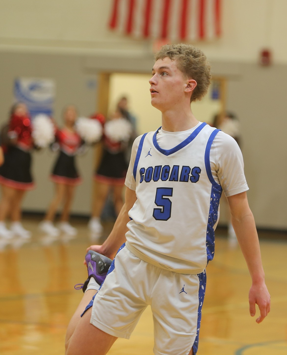 Cougars senior Eli Cox stretches while looking at the scoreboard between free throw shots earlier this season.