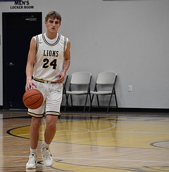 MLCA/CCS senior Johnny Ferguson dribbles the ball down the court during a home game earlier this season. The Lions kept their season alive Wednesday afternoon to move on to the quarterfinals of state.