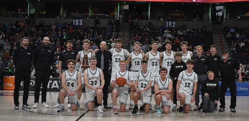 The ACH Warriors boys basketball team gathers for a team photo after receiving their fifth place trophy in the 1B state tournament.