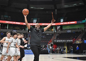 Moses Lake Christian Academy/Covenant Christian School Lions Head Coach Emerson Ferguson walks off the court with the game ball in one hand and the team’s fourth place trophy in the other hand with his team behind him after coming out victorious in the state finals. Ferguson had also earned the title of Central Washington B League 2025/2026 Coach of the Year earlier in the postseason, which he attributes to the hard work from his players and assistant coaches, Curtis Weber and Kameron Firouzi.