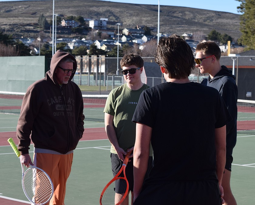 Coach Greg Becker, with white racket, speaks with Avery Morris, in green shirt, and other members of the Tigers varsity tennis team Monday at the beginning of practice. Becker said Morris and Mitch Morford, far right, have a lot of skill and leadership potential.