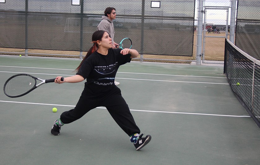 Allison Pedroza sets up her shot during practice, while Francisco Sandoval Jr. waits his turn. About 35 girls turned out for the 2026 tennis team, said head coach Joahan Fregoso.