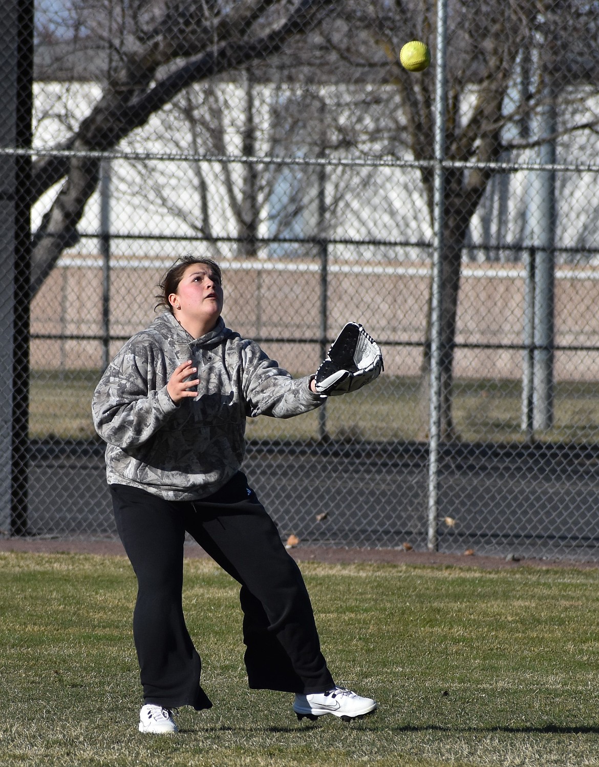 MLCA/CCS sophomore Elisa Serrato prepares to catch the ball hit to her in the outfield by Head Coach Todd Gregory.