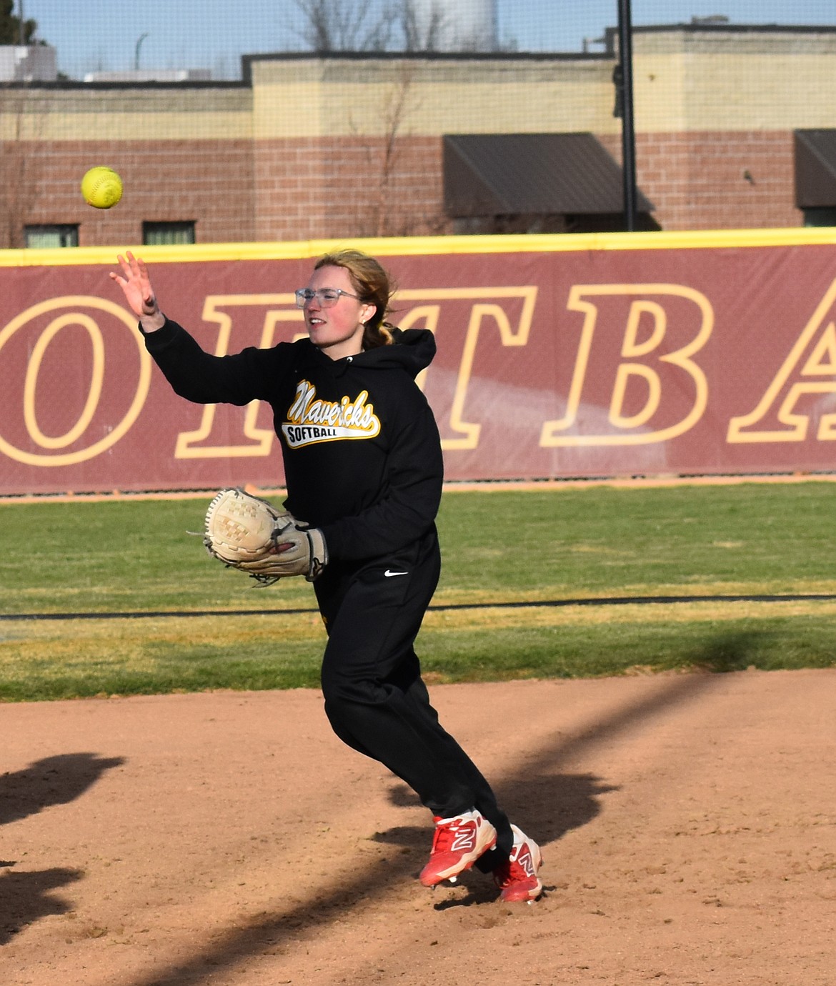 Josie Carlstrom throws the ball at softball practice.