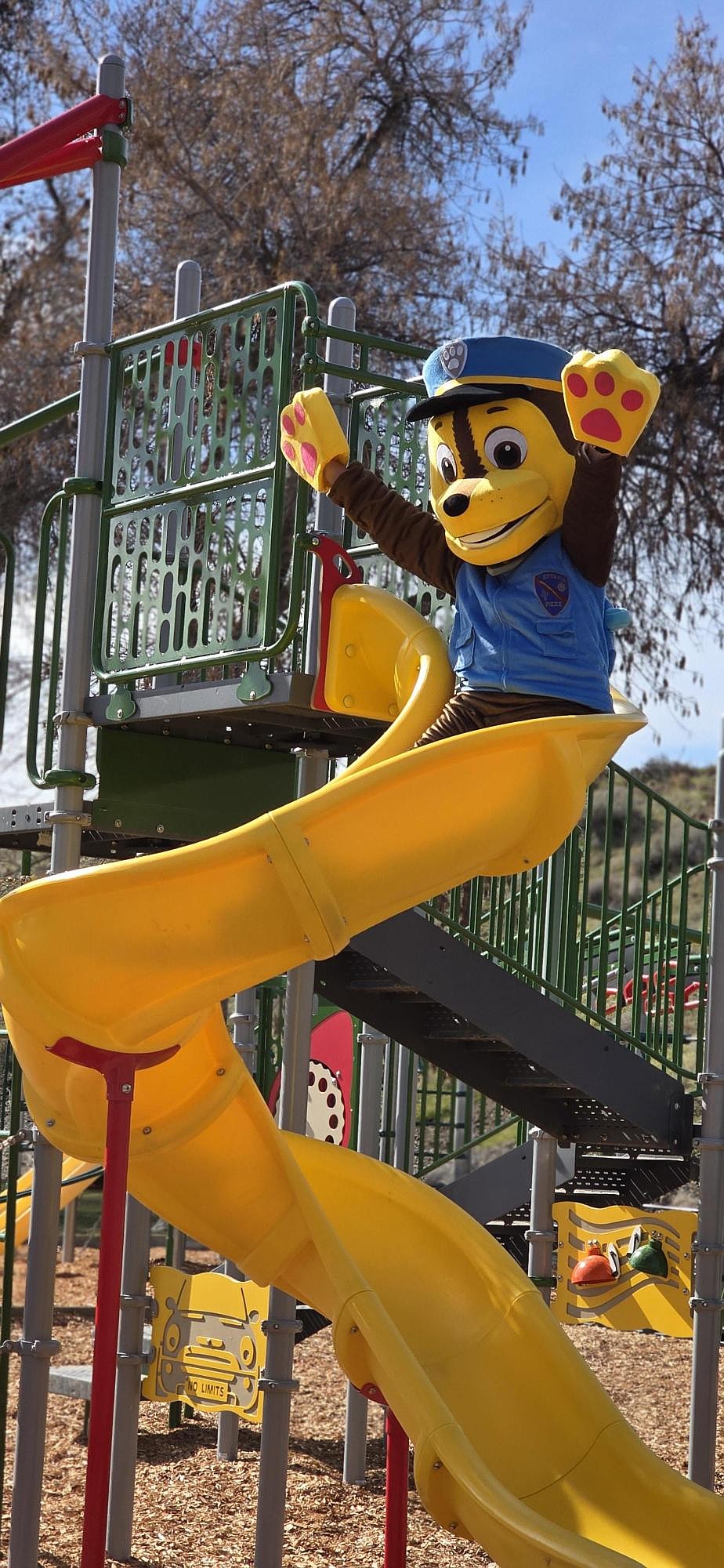 Ephrata Police Department Manager Jennifer Hansen, dressed in a special uniform for the opening of the new playground at Ephrata’s Lions Park, tests out the newly installed slide.