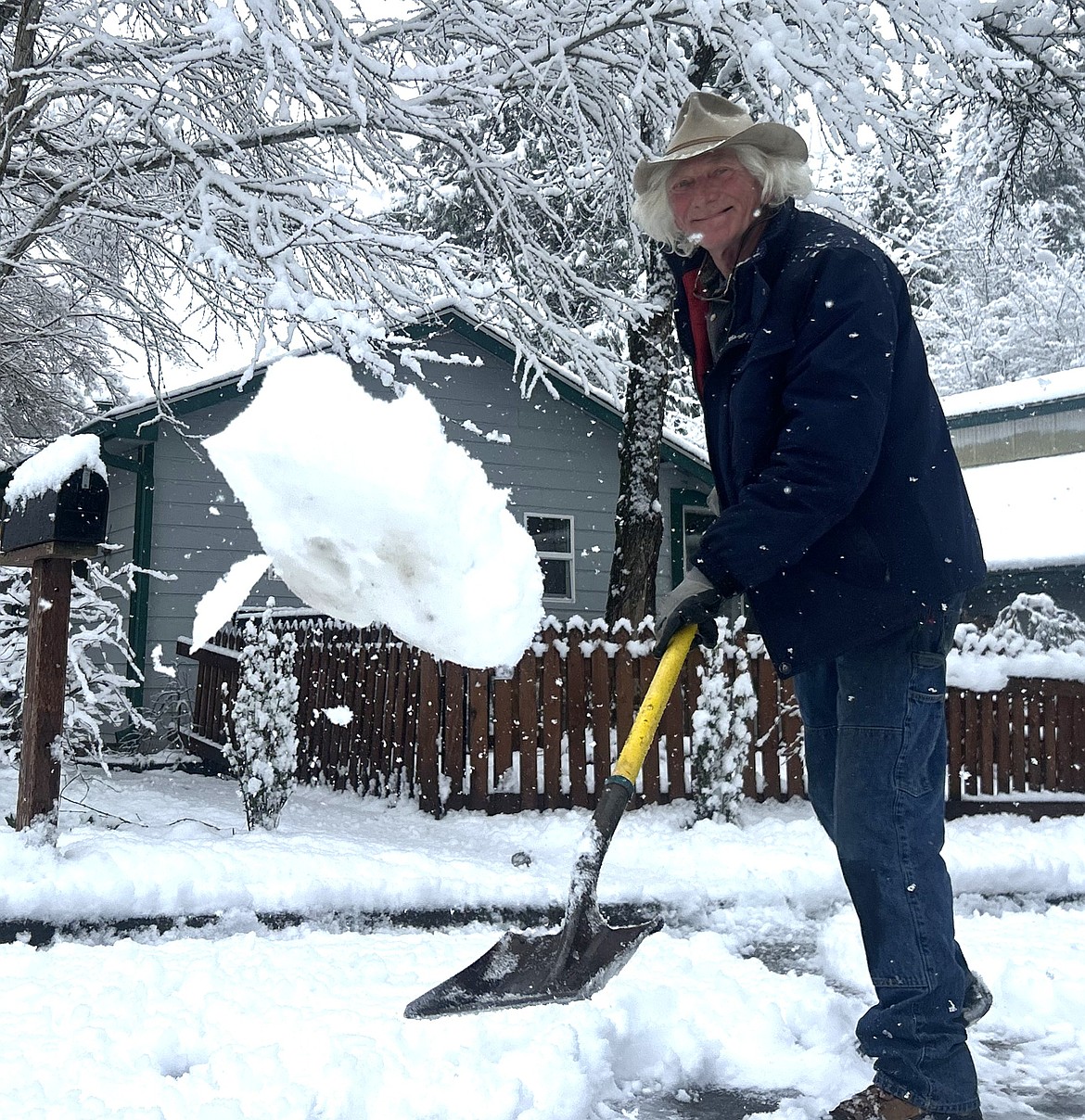 Eric York shovels snow with a smile near his Coeur d'Alene home on Friday morning.