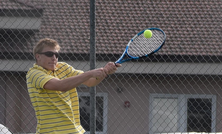 Cael Orth from the Knights hits the ball back over to his opponent in the boys first singles match early during the late afternoon meet against Naches Valley.
