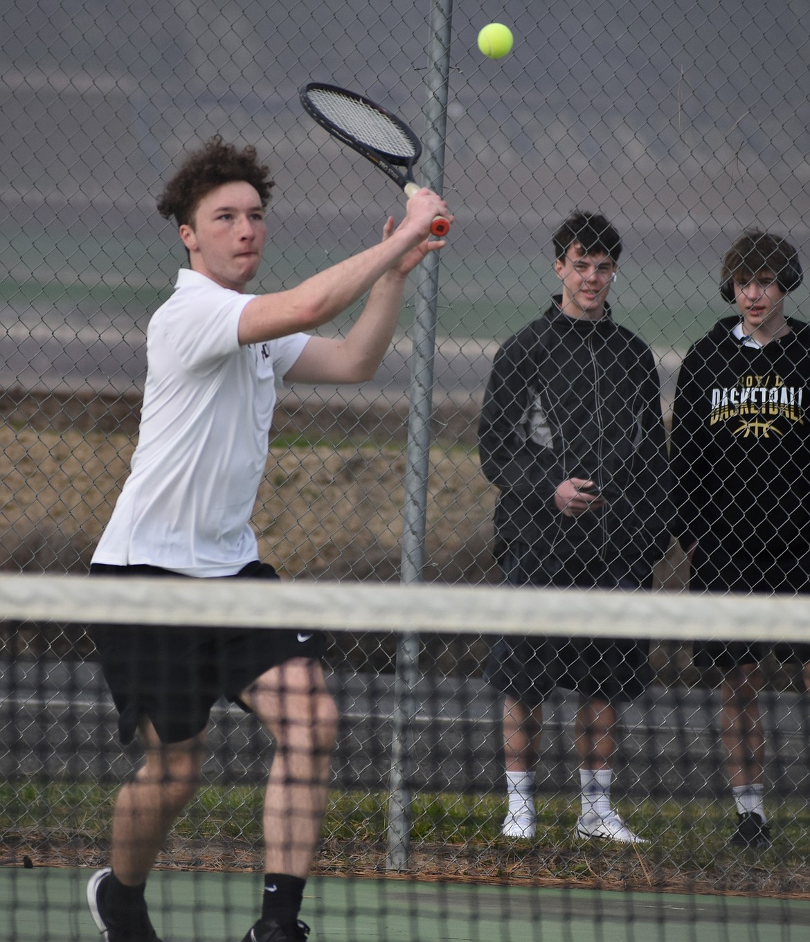 K.J. Greenfield from Royal moves toward the ball to send it back over the net to his opponents from Naches Valley.
