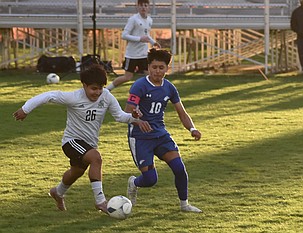 Royal senior Jeonatan Dircio (26) quickly moves the ball down the field as Warden senior Jose Perez (10) works to take possession of the ball.