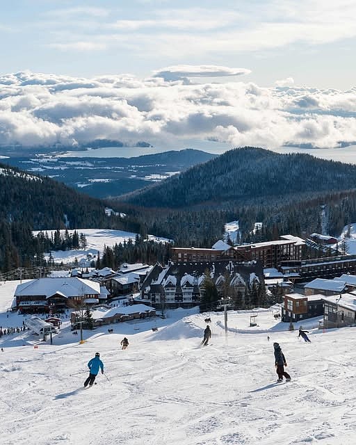 Skiers glide downhill at Schweitzer Mountain Resort.