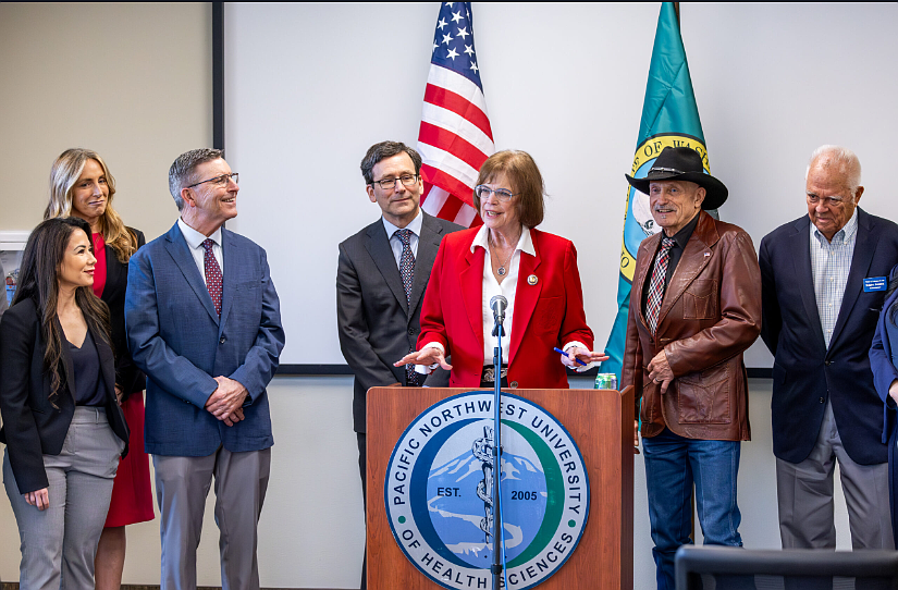 Senator Judy Warnick, at podium, talks about the last bill she sponsored in her legislative career during the signing ceremony in Yakima. Behind Warnick is Gov. Bob Ferguson who signed the bill into law.