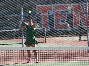 Kim Solano-Garcia, in green, tosses the ball in the air before taking her next serve. The Quincy Jacks boys and girls teams were victorious against the Ephrata Tigers Thursday.