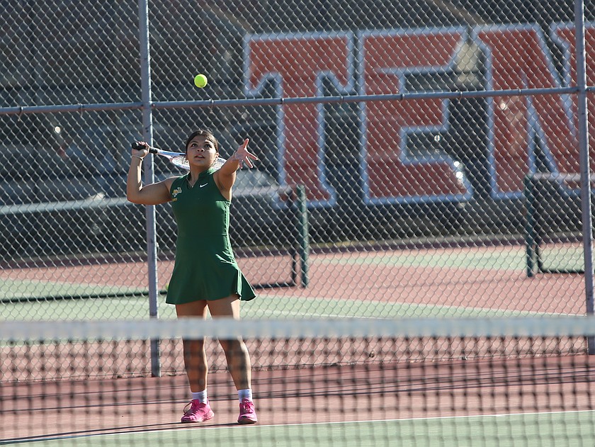 Kim Solano-Garcia, in green, tosses the ball in the air before taking her next serve. The Quincy Jacks boys and girls teams were victorious against the Ephrata Tigers Thursday.