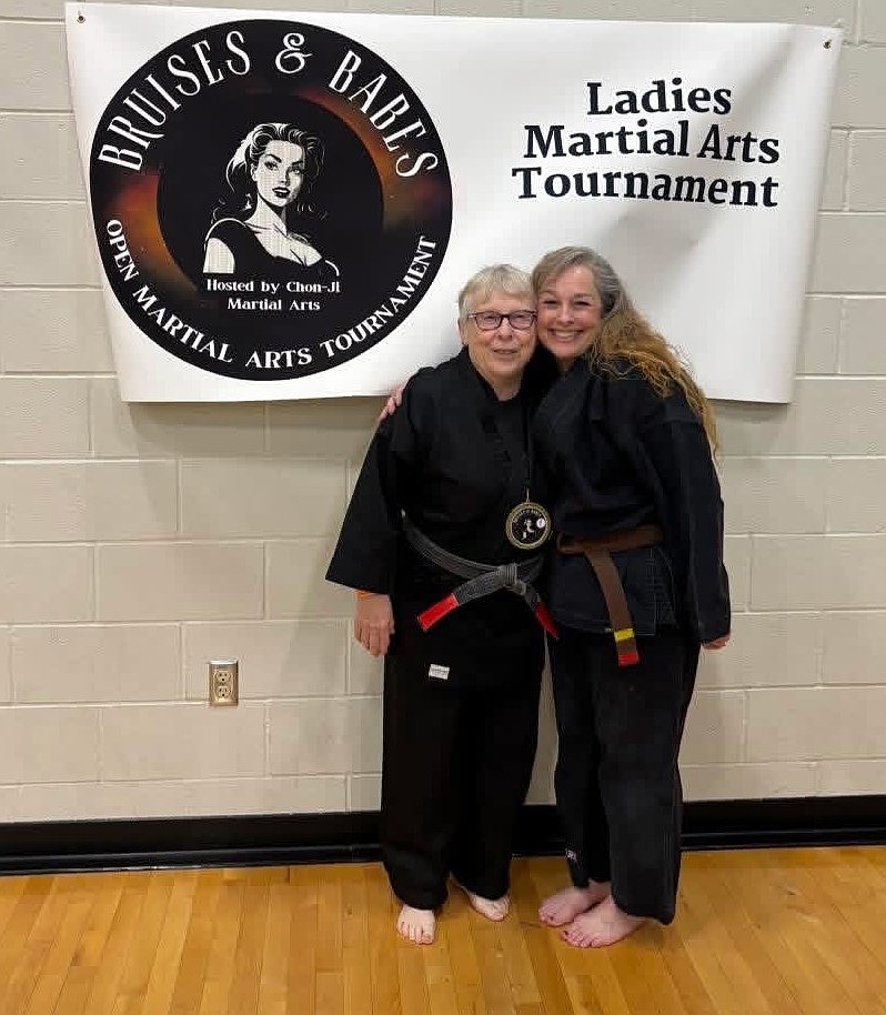 Brandi Guertin, right, shares a moment with a fellow competitor at the Bruises and Babes martial arts tournament.